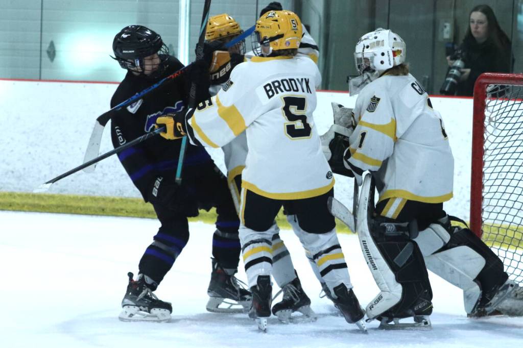 Vernon Watkin Motors Mustangs forward Oliver Baines (left) is kept away from Edmonton KC Lancers goalie Finn Gale by defenceman Kaiden Brodyk during the opening game of the 53rd Vernon Coca Cola Classic Pee Wee Hockey Tournament Thursday, Feb. 12, at Kal Tire Place North. Brodyk scored in overtime to give Edmonton a 5-4 win over the hosts. (Roger Knox - Morning Star)